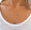 Gold filled turquoise initial necklace worn with a white scoop-neck tee