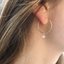 Ethiopian opal gold hoop earring worn close-up