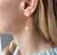 Close-up of a faceted opal gold threader earring