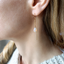 Faceted opal threader earring close-up showing the stone's fire