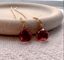 Faceted garnet briolette threader earrings on a ceramic dish