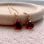 Garnet threader earrings with faceted garnet briolette drops resting on a stone dish