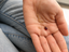Hand holding a dainty gold-filled garnet teardrop necklace