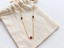 Garnet 3 bead station necklace on a cotton gift pouch