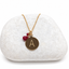 Gold-filled initial disc necklace stamped with A and genuine ruby teardrop and rondelle charms on a white stone
