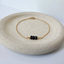 Gold filled bracelet with three black faceted onyx beads on a stone dish