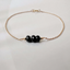 Gold filled black onyx bracelet on a textured stone surface
