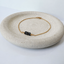 Minimalist gold bracelet with three black gemstones