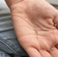 Gold-filled cubic zirconia station necklace held in the palm to show scale