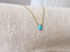 Gold filled turquoise teardrop necklace draped on linen - Lolabean