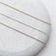 Gold filled, sterling silver, and rose gold filled dainty chain necklaces displayed side by side.
