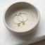 Gold citrine hoop earrings in a speckled ceramic dish