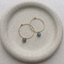 Gold hoops with labradorite dangles on a stone dish