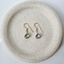 Gold labradorite earrings on a speckled plate