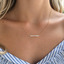 Minimal gold opal bar necklace close-up on the collarbone