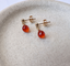 Pair of gold-filled carnelian stud earrings in a stone dish