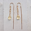 Gold filled citrine paperclip earrings laid flat on white plaster