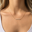 Close-up of gold opal bar necklace showing opal play of color