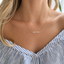 Gold opal beaded necklace layered over an open-collar shirt