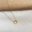 Gold citrine necklace on a light gray surface with a brown paper background