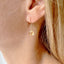 Gold citrine drop earring worn by a person with blonde hair.