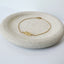Gold citrine bracelet on a round stone surface with a white background