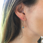 Iridescent labradorite hoop earring worn close-up