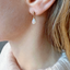 Close-up of an opal teardrop stud earring showing play of color