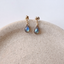 Labradorite teardrop stud earrings in gold-filled and sterling silver on a stone tray