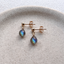 Gold-filled labradorite drop stud earrings on a ceramic dish