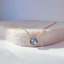 Faceted labradorite pendant showing blue flash on a stone display