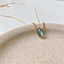Labradorite teardrop necklace in 14k gold-filled on a stone dish