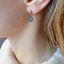 Close-up of a labradorite stud earring worn on the ear
