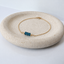 London blue topaz three-bead bracelet with a fine 14k gold-filled chain and spring ring clasp on a textured stone dish
