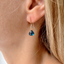 Model wearing a gold-filled London blue topaz dangle earring
