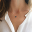 London blue topaz necklace in gold filled worn with a white blouse
