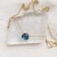 Gold-filled London blue topaz heart necklace with spring ring clasp on a clear crystal