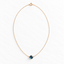 Dainty London blue topaz necklace with spring ring clasp laid flat on white
