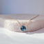 Dainty London blue topaz necklace in 14k gold filled with a faceted deep blue topaz heart briolette on a felt display