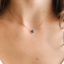 Model wearing the gold-filled dainty London blue topaz necklace at the collarbone