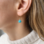 Turquoise dangle earring worn on the ear with a cream sweater, gold filled ear wire