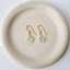 Pale green prehnite drop earrings in 14k gold-filled on a stoneware plate