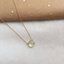 Gold-filled prehnite necklace on kraft paper with gold confetti