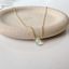 Prehnite teardrop necklace in 14k gold-filled with a faceted mint green prehnite on a stone dish