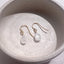     Pear shaped moonstone drop earrings displayed on a round neutral jewelry dish with gold filled ear wires