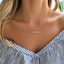 Dainty opal bar necklace on a gold chain in natural light