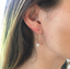 Opal hoop earring worn with blonde hair