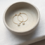 Gold opal hoops in a speckled ceramic bowl