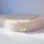 Close-up of a faceted prehnite heart briolette wire-wrapped into a 14k gold-filled chain