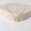 Dainty prehnite necklace in 14k gold-filled with a faceted mint green prehnite heart on a textured stone display